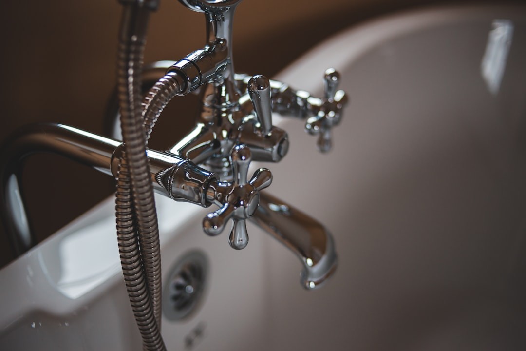 silver water faucet on white ceramic sink